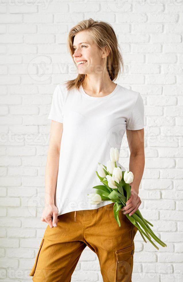 Young woman wearing blank white t-shirt holding tulips flowers photo