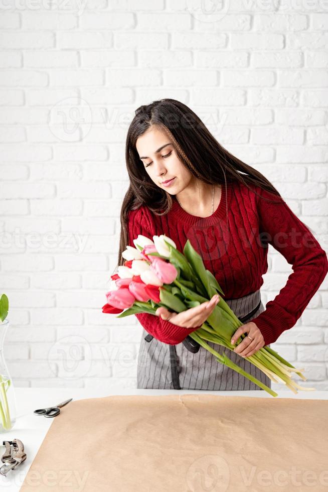 Mujer floristería haciendo un ramo de tulipanes coloridos frescos foto