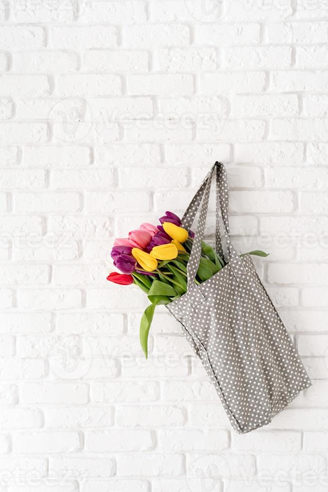 Gray polka dot fabric bag full of colorful tulips photo