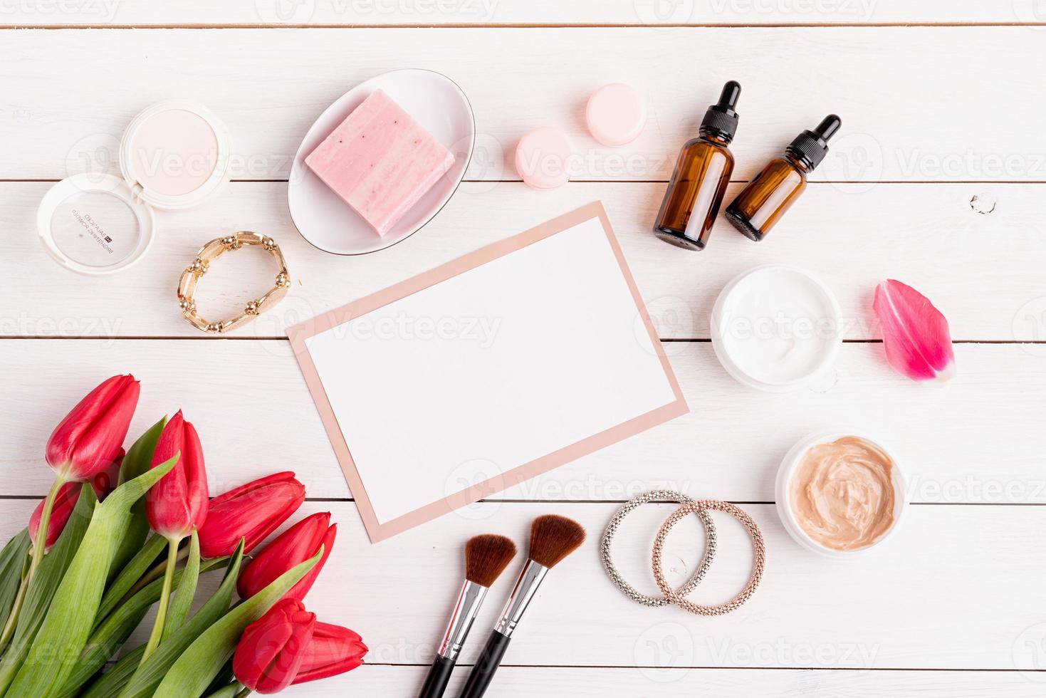 Top view of cosmetics with pink tulips top view flat lay photo