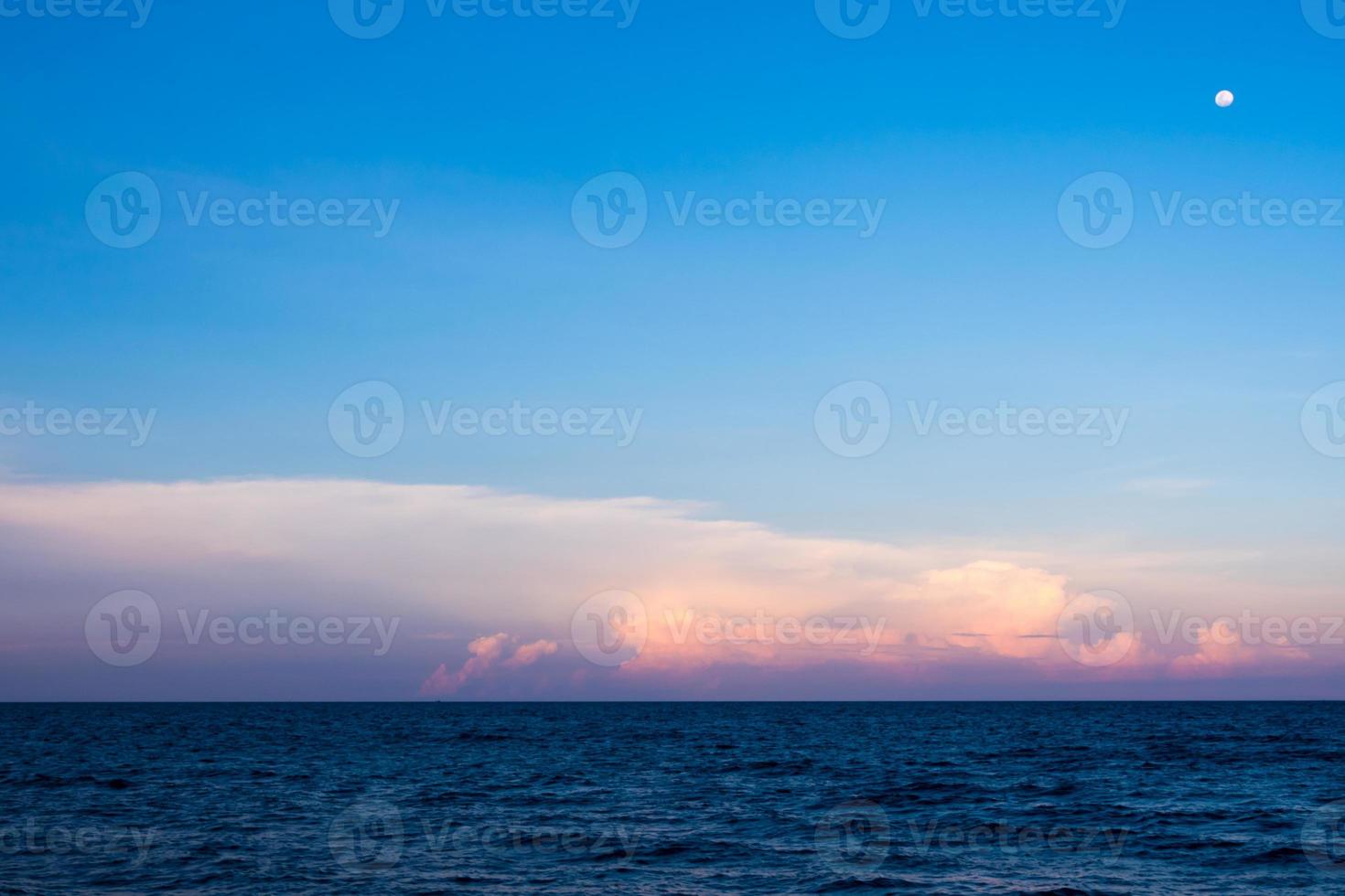 nubes y luna en el cielo del atardecer sobre el mar foto