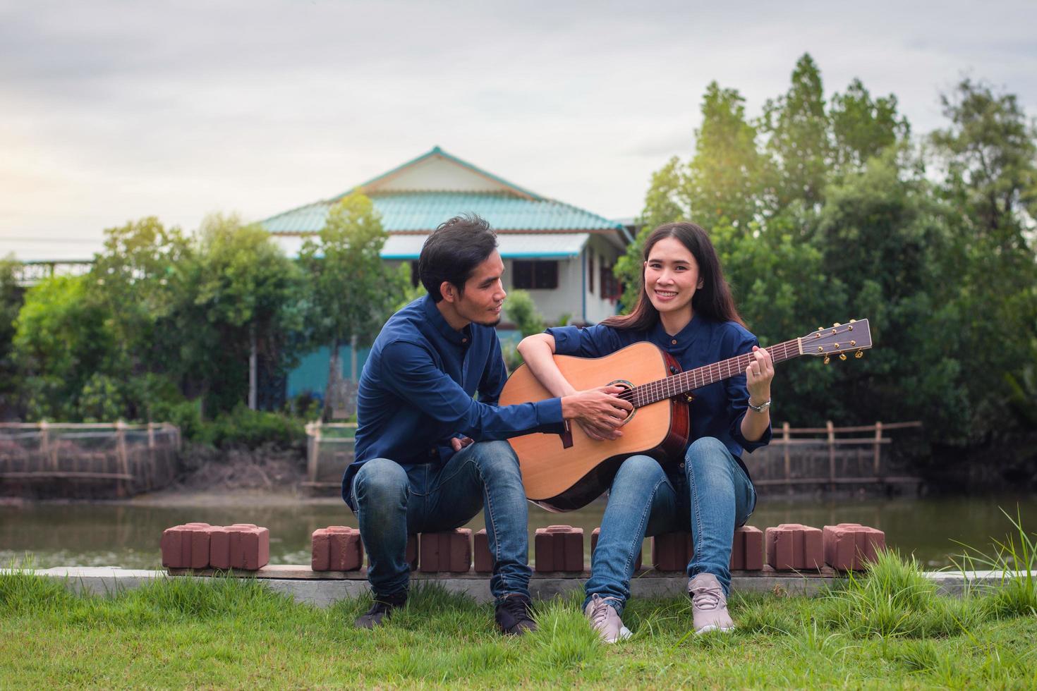 Family couple playing guitar in garden at home photo