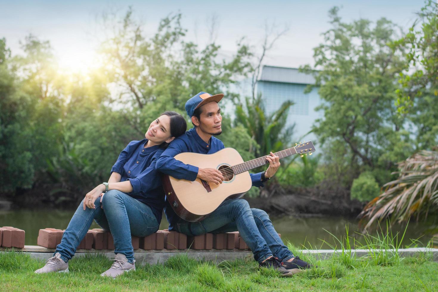 pareja asiática tocando la guitarra resto en verano foto