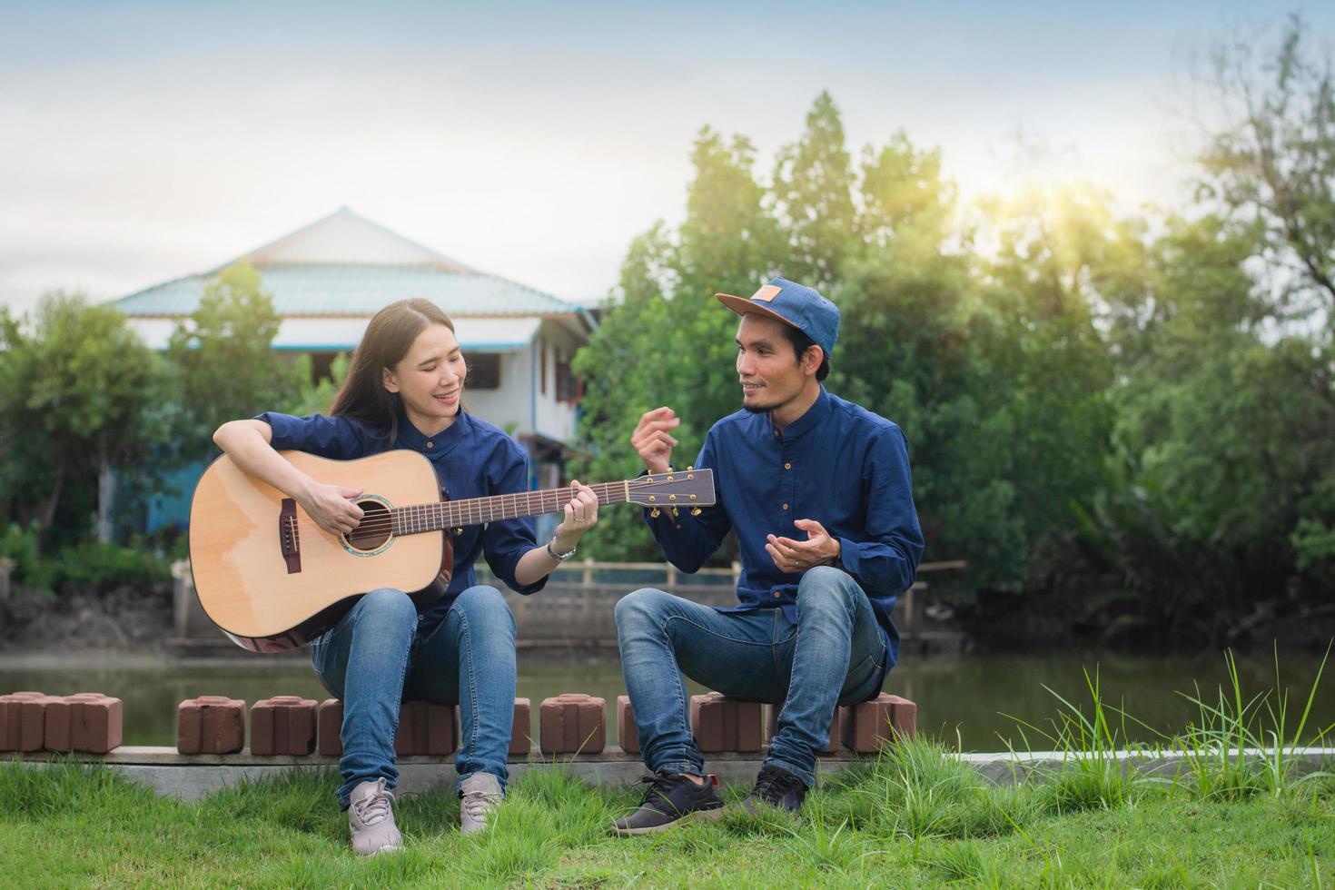 Two people friends play guitar rest in summer happy in holiday photo