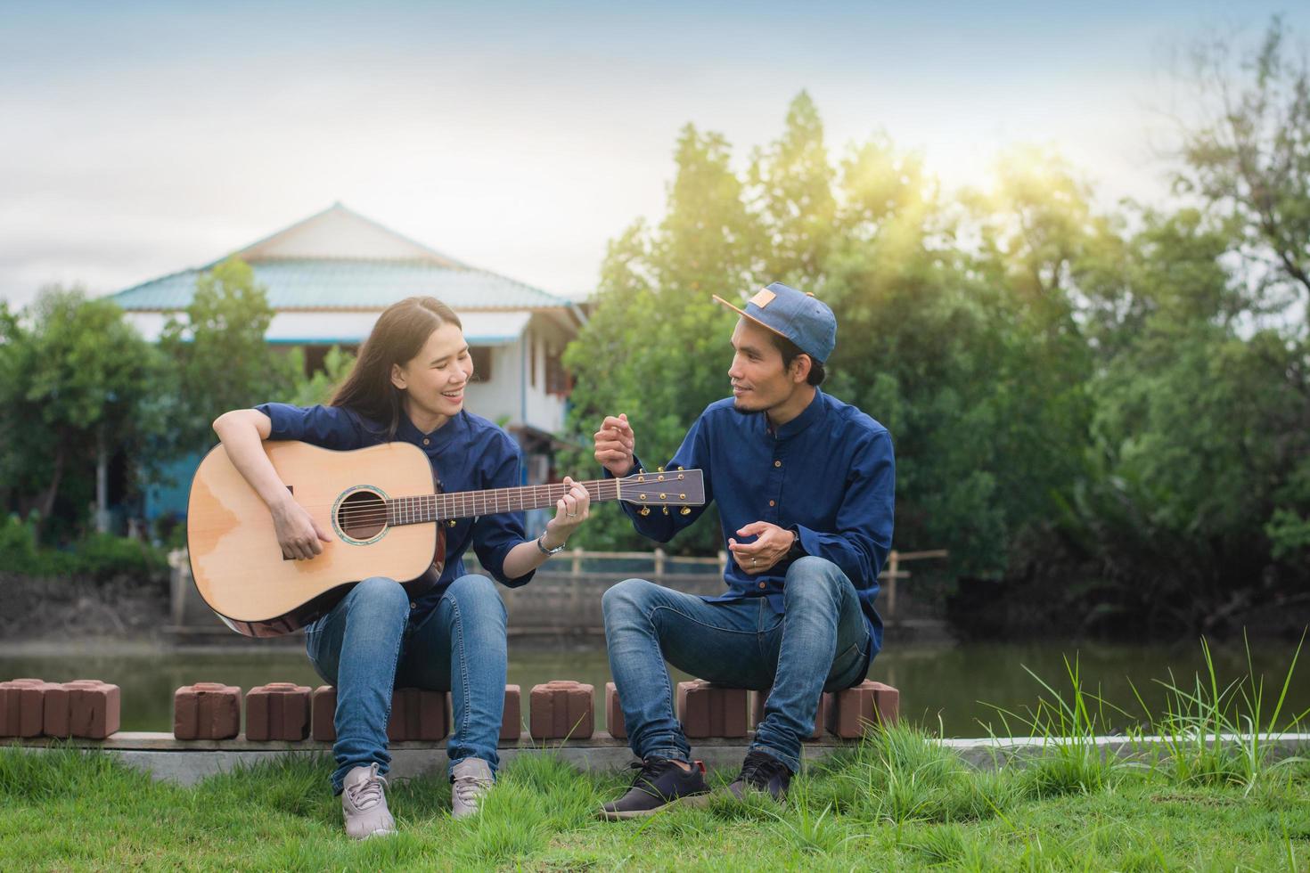 amigos tocar la guitarra juntos al aire libre descansar en vacaciones de verano foto