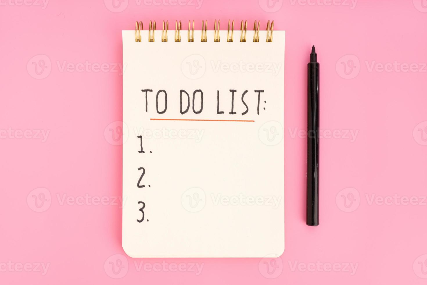 To do list in spiral notepad isolated on pink background. Top view photo