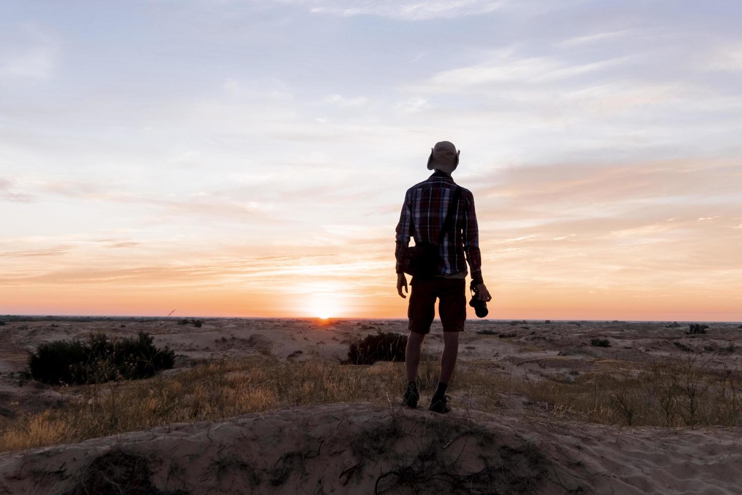 Young male traveler with photo camera in the desert