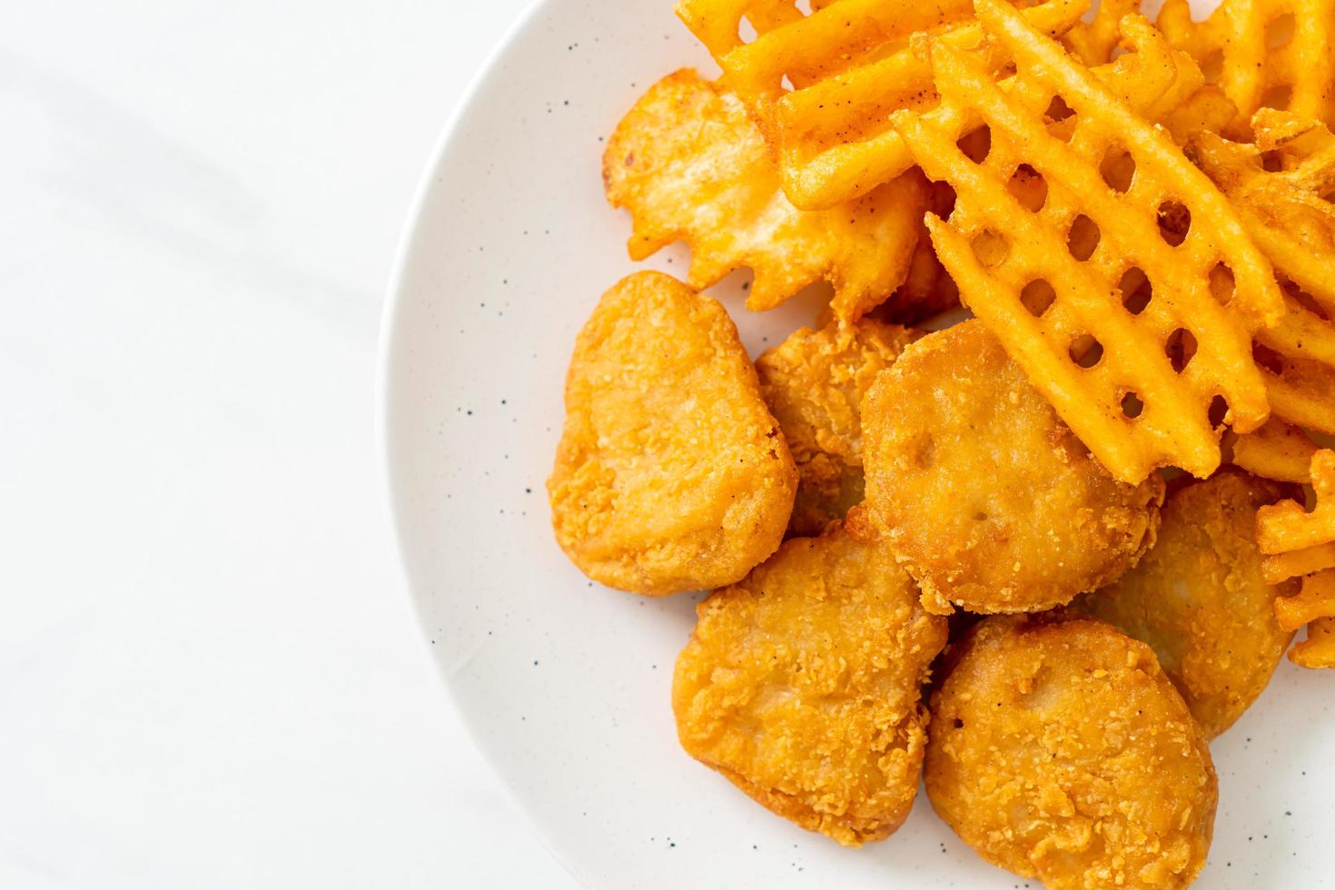 Fried chicken nuggets with fried potatoes photo