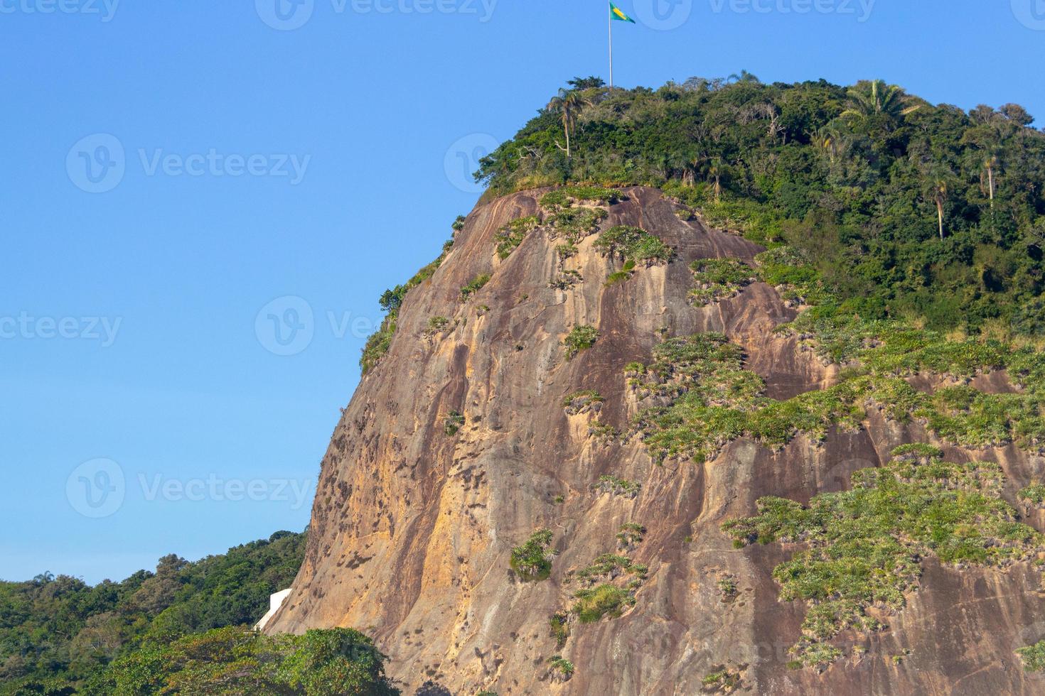Helm Stone con la bandera de Brasil en la parte superior, visto desde la playa de Helm en Río de Janeiro, Brasil foto
