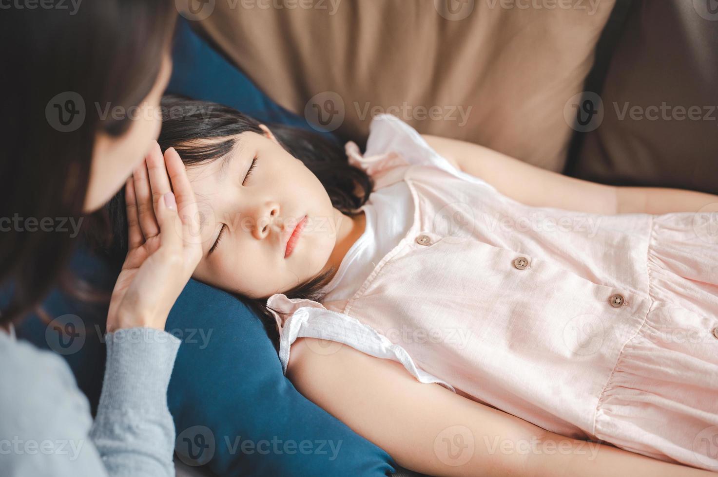 niña asiática enferma durmiendo en el sofá foto