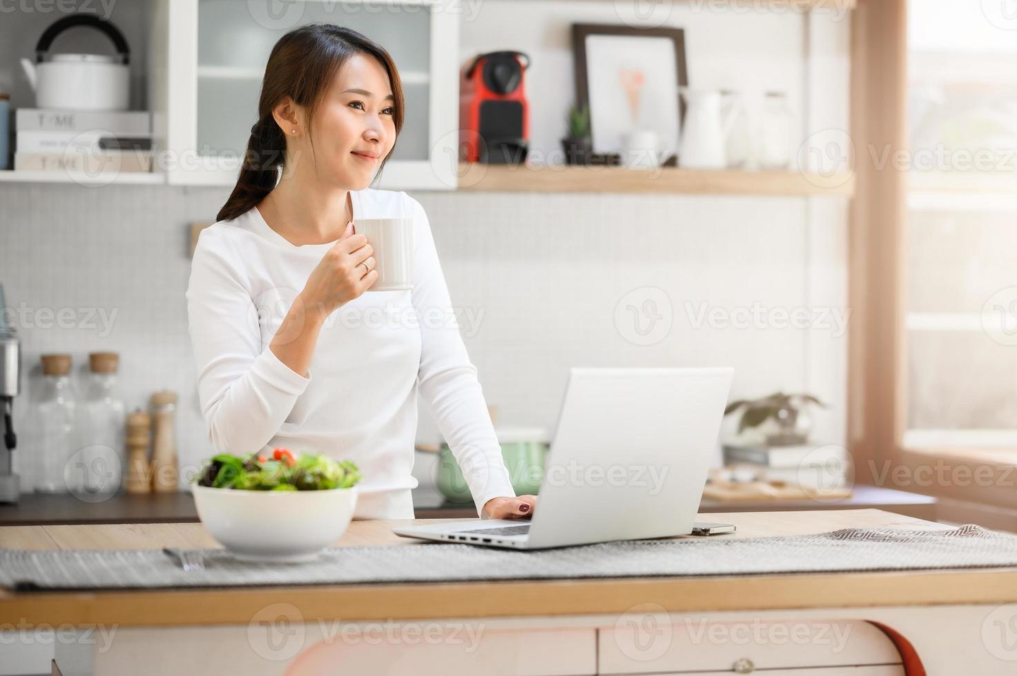 Asian woman having a coffee break while working from home photo