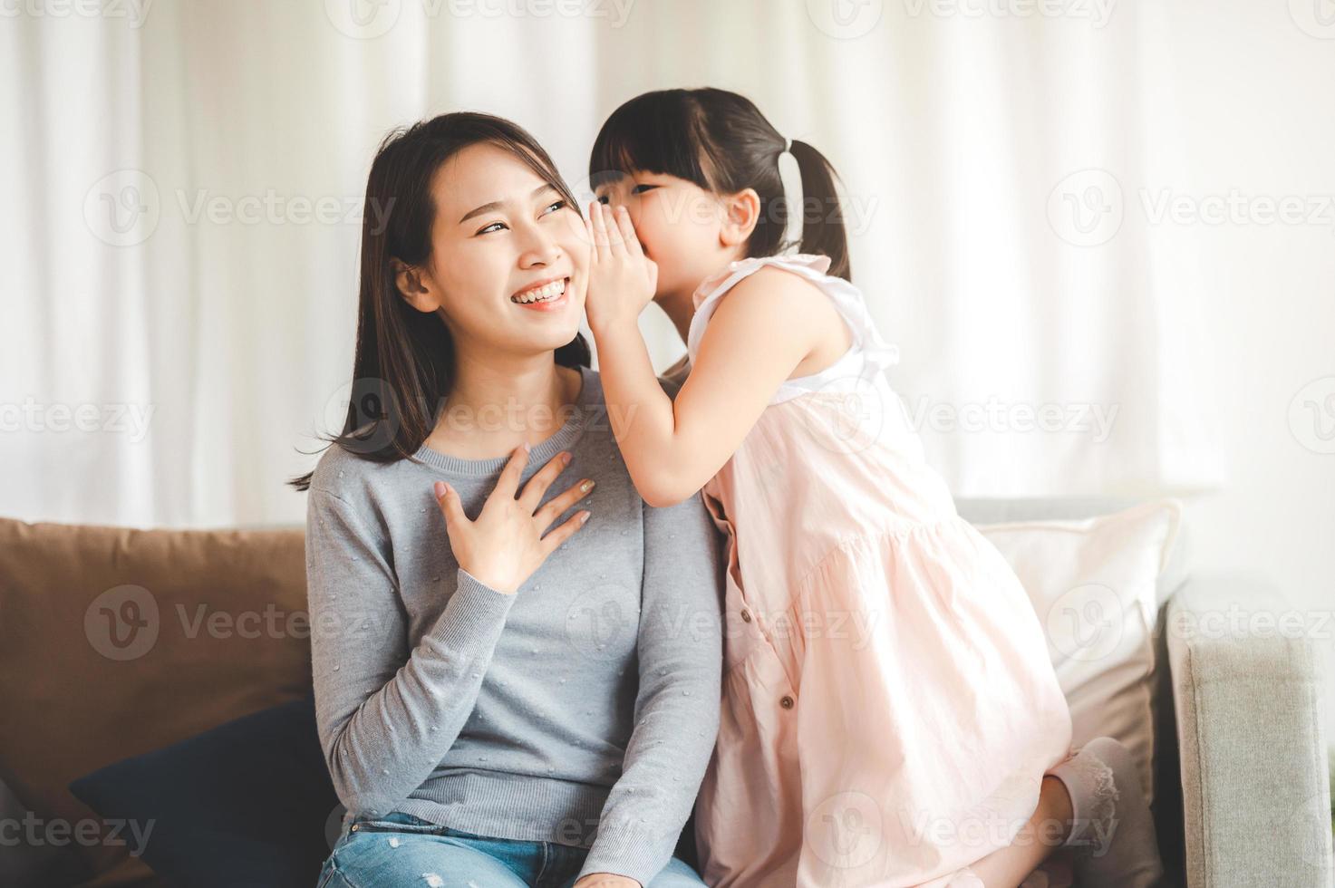 Little girl whispering a secret to mom photo