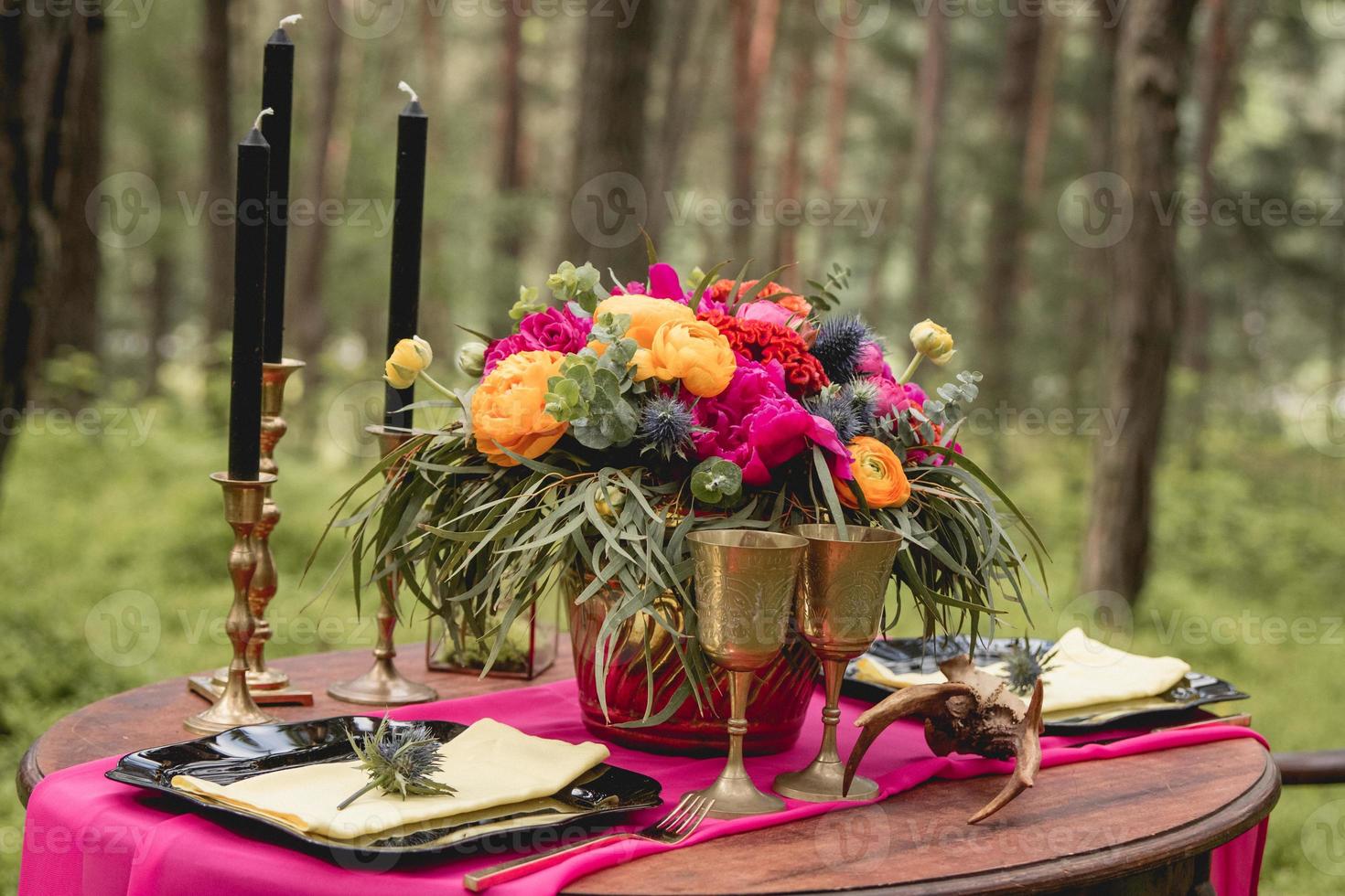 Decorated wooden table with flowers, candles, utensils photo