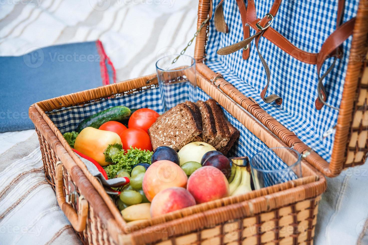 Cesta de picnic con fruta y pan de cerca foto