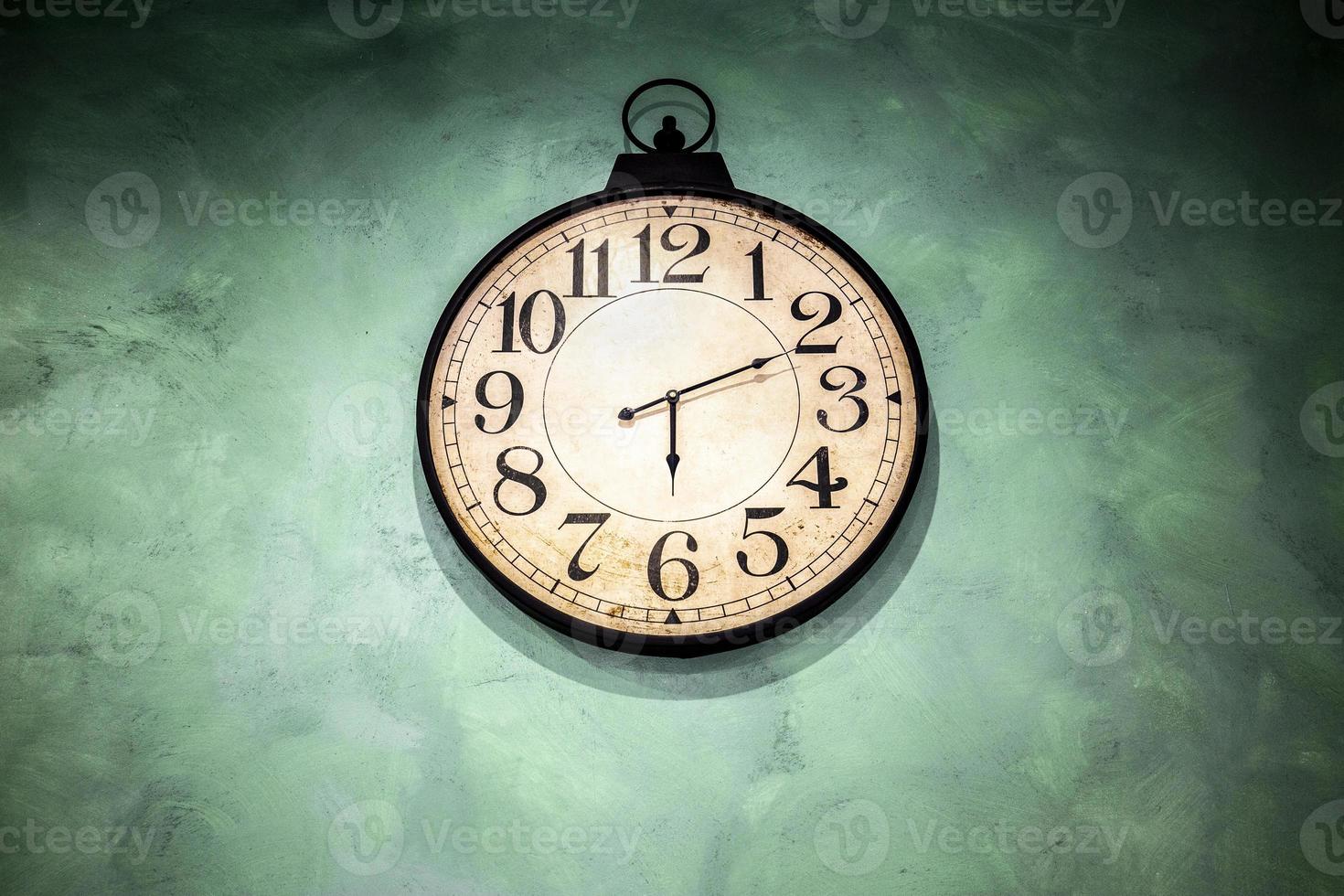 Vintage watch hanging on green wall photo