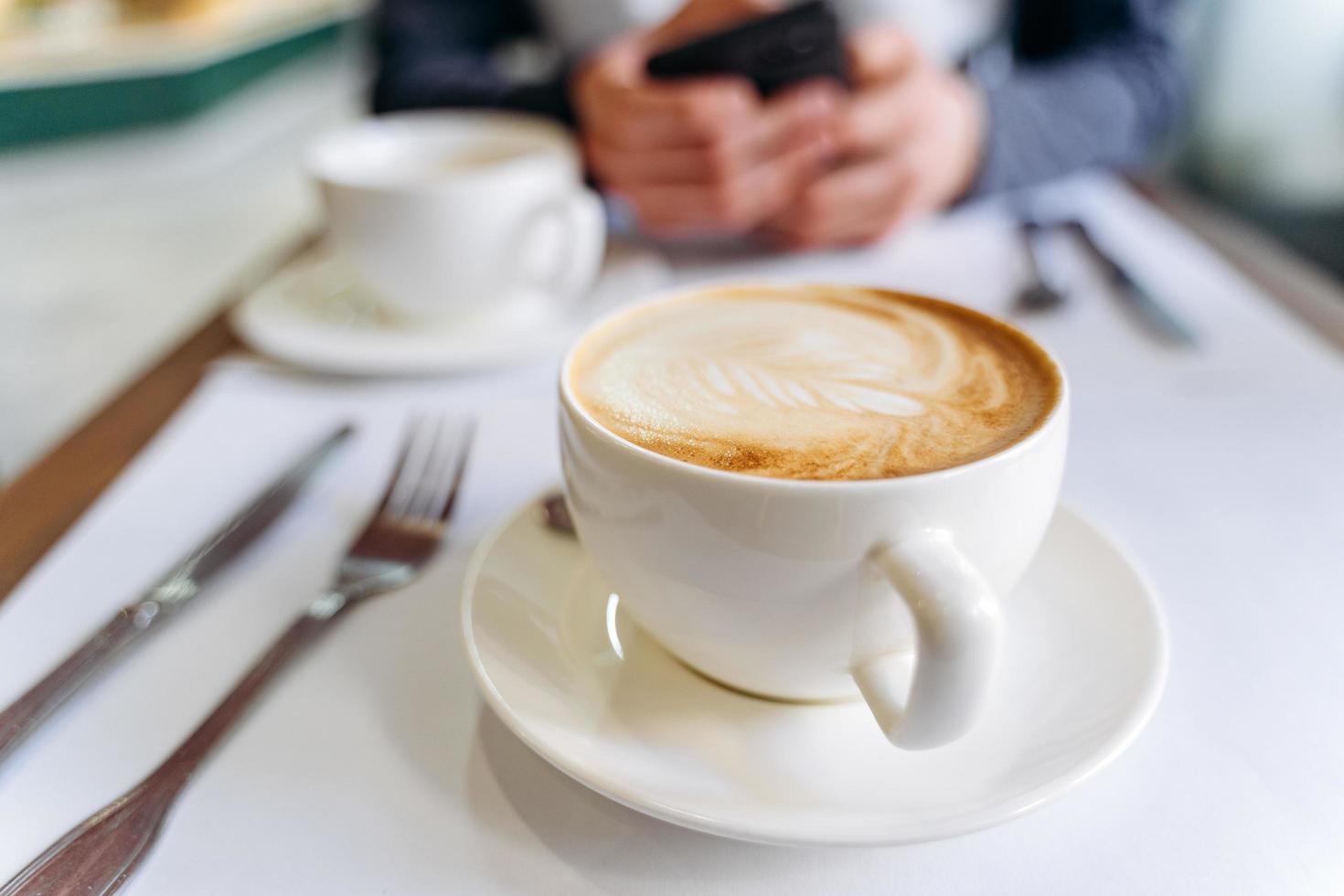 White cup of coffee on the table in a coffee shop. photo