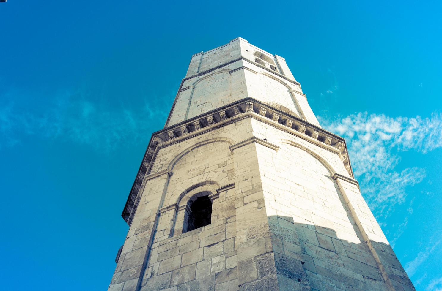 La torre de una iglesia medieval católica en Italia con una ventana foto