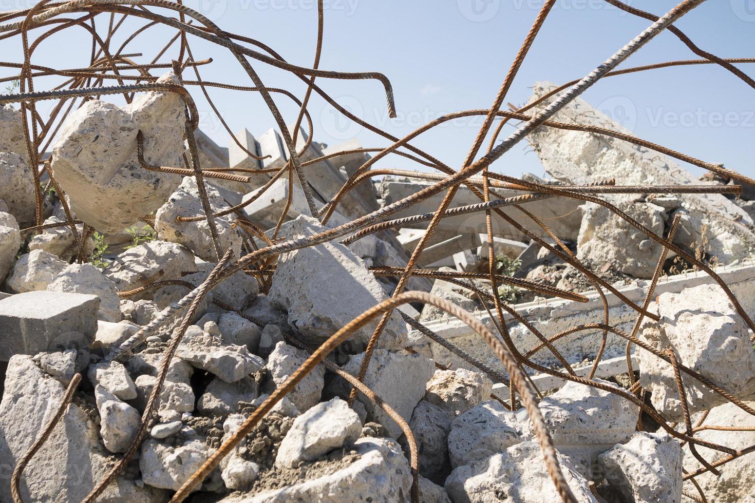 Heap of construction debris, pieces of broken concrete, metal rods photo