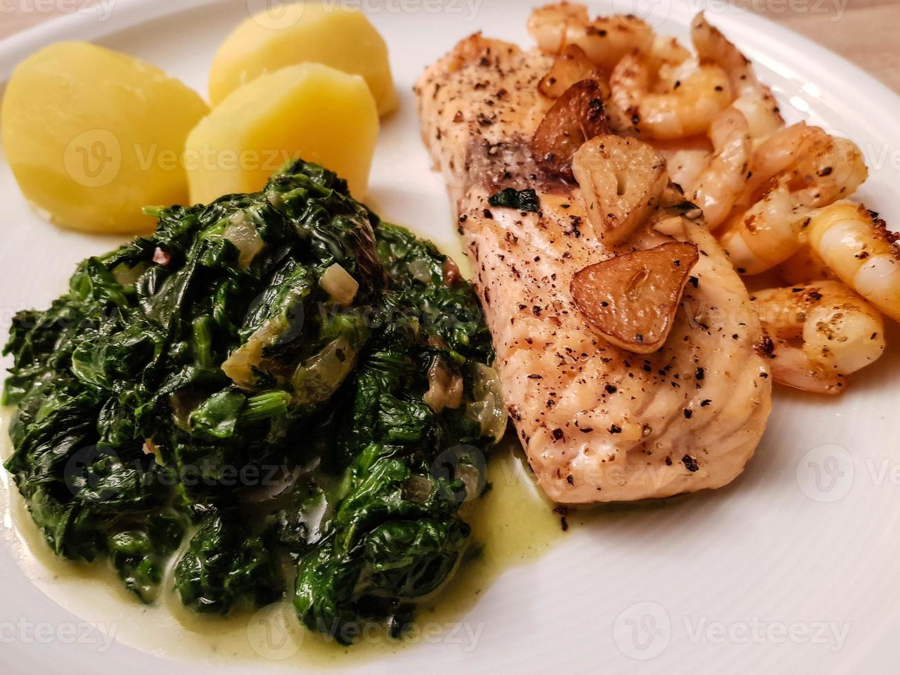 Salmon steak with creamed spinach and baked potatoes photo