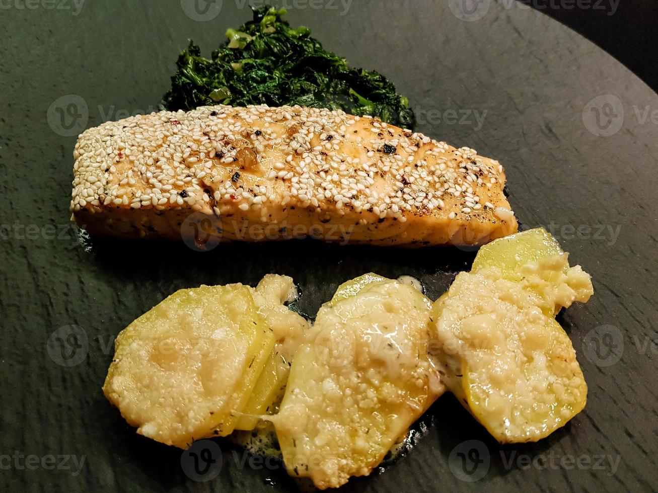 Salmon steak with creamed spinach and baked potatoes photo