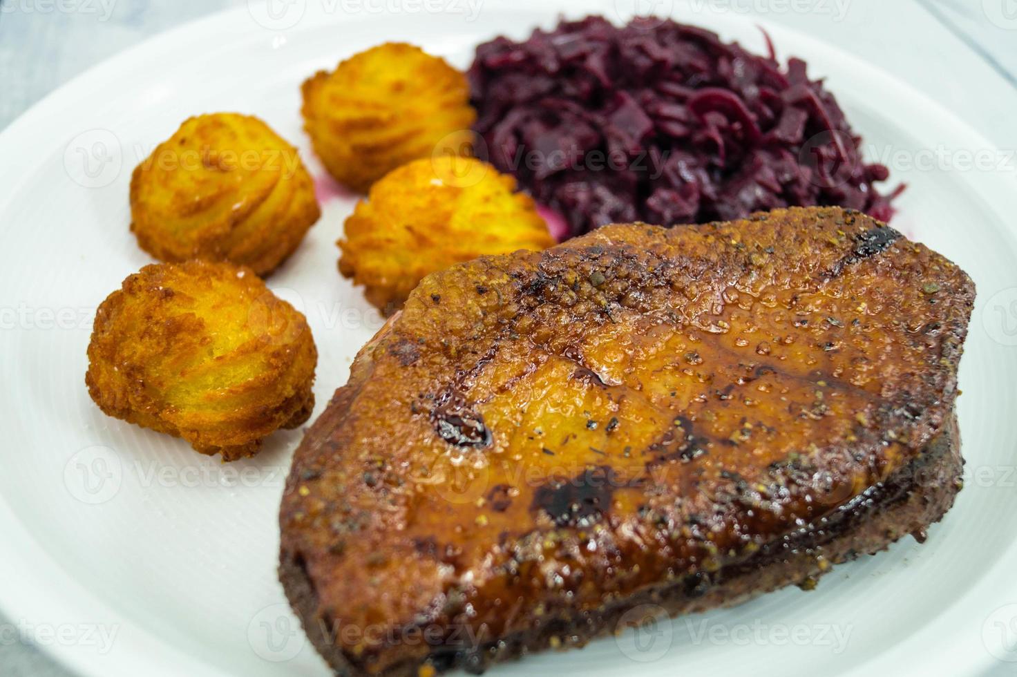 Magret de pato frito con col lombarda y croquetas foto