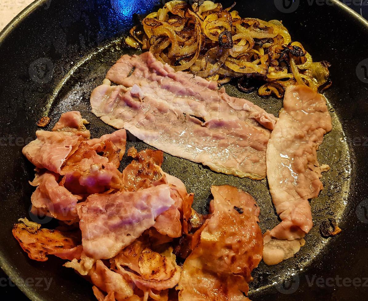 Preparing a Baconburger with grilled Burgundy Bacon and roasted onions photo