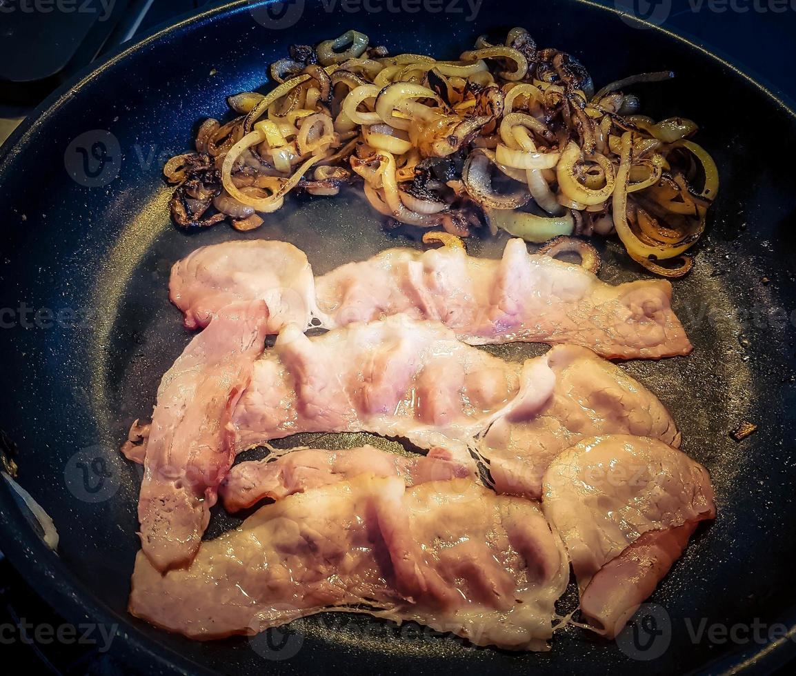 Preparing a Baconburger with grilled Burgundy Bacon and roasted onions photo