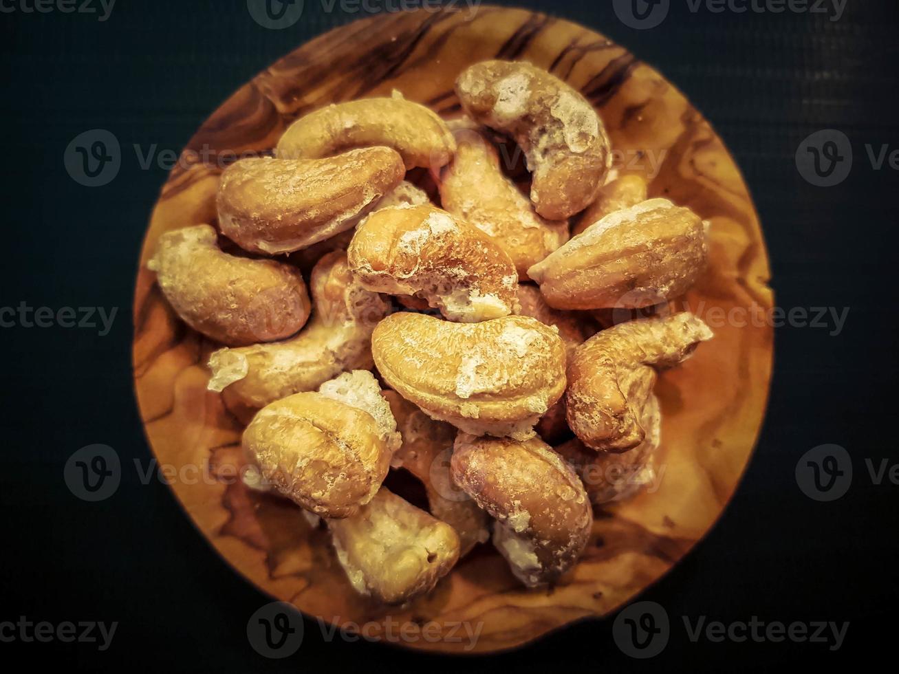 A pile of cashew nuts on olive wood photo