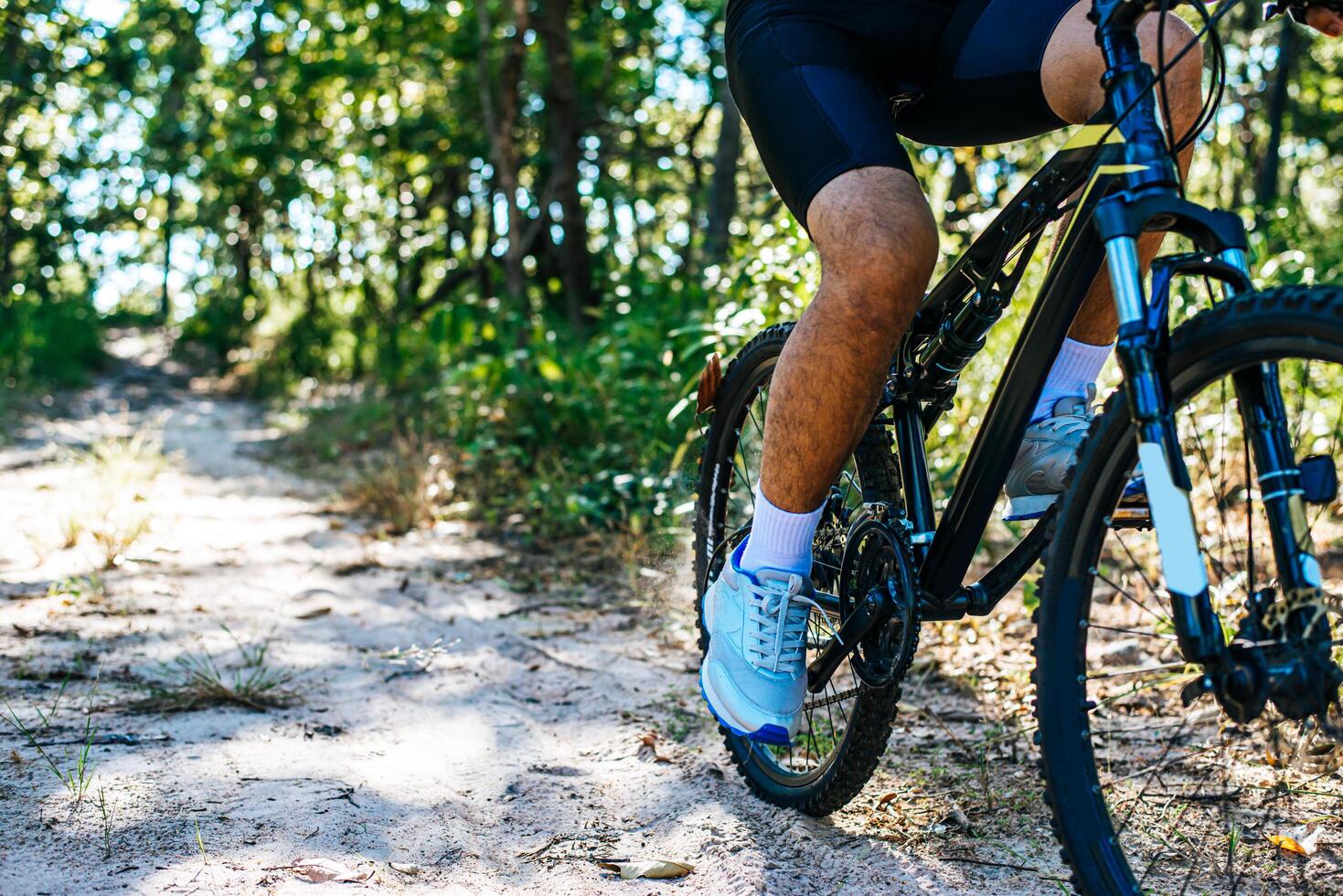 Una baja perspectiva de los ciclistas de montaña en un camino rocoso se centran en los zapatos foto