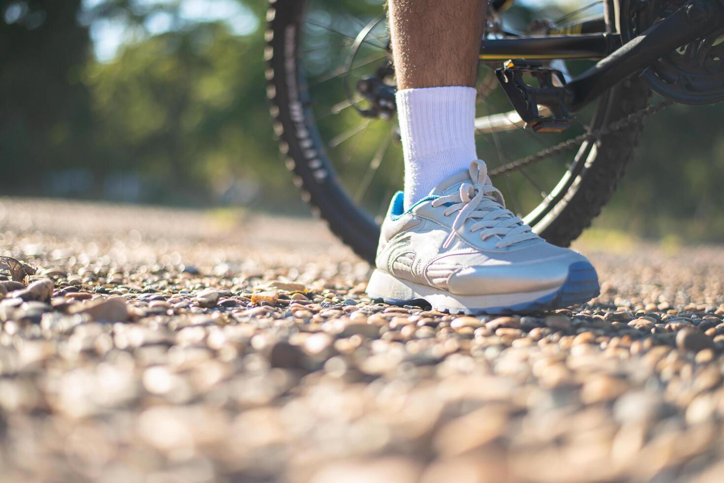 Una baja perspectiva de los ciclistas de montaña en un camino rocoso se centran en los zapatos foto