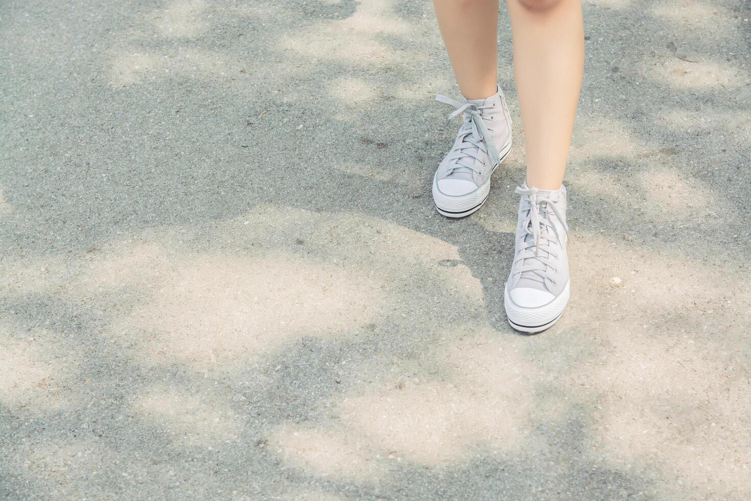 Woman feets walking on the road in the park photo