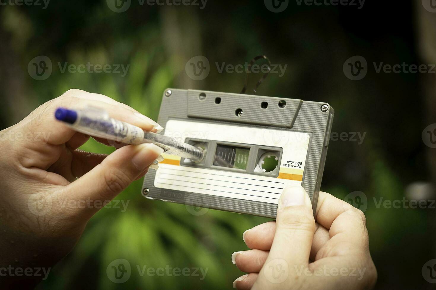 Las mujeres rebobinan una cinta de cassette. foto