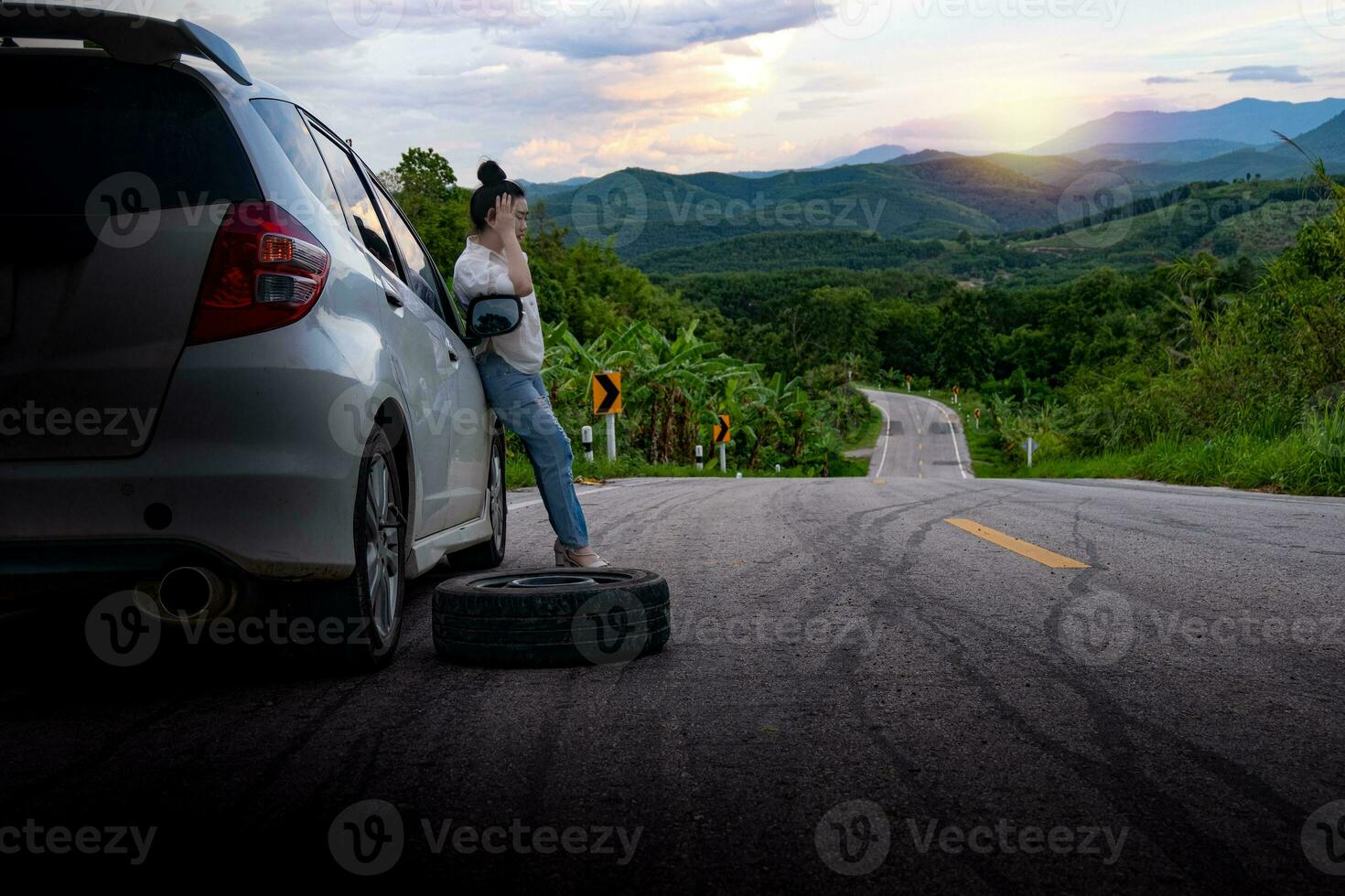 Young beautiful lady standing near car for calling for help photo