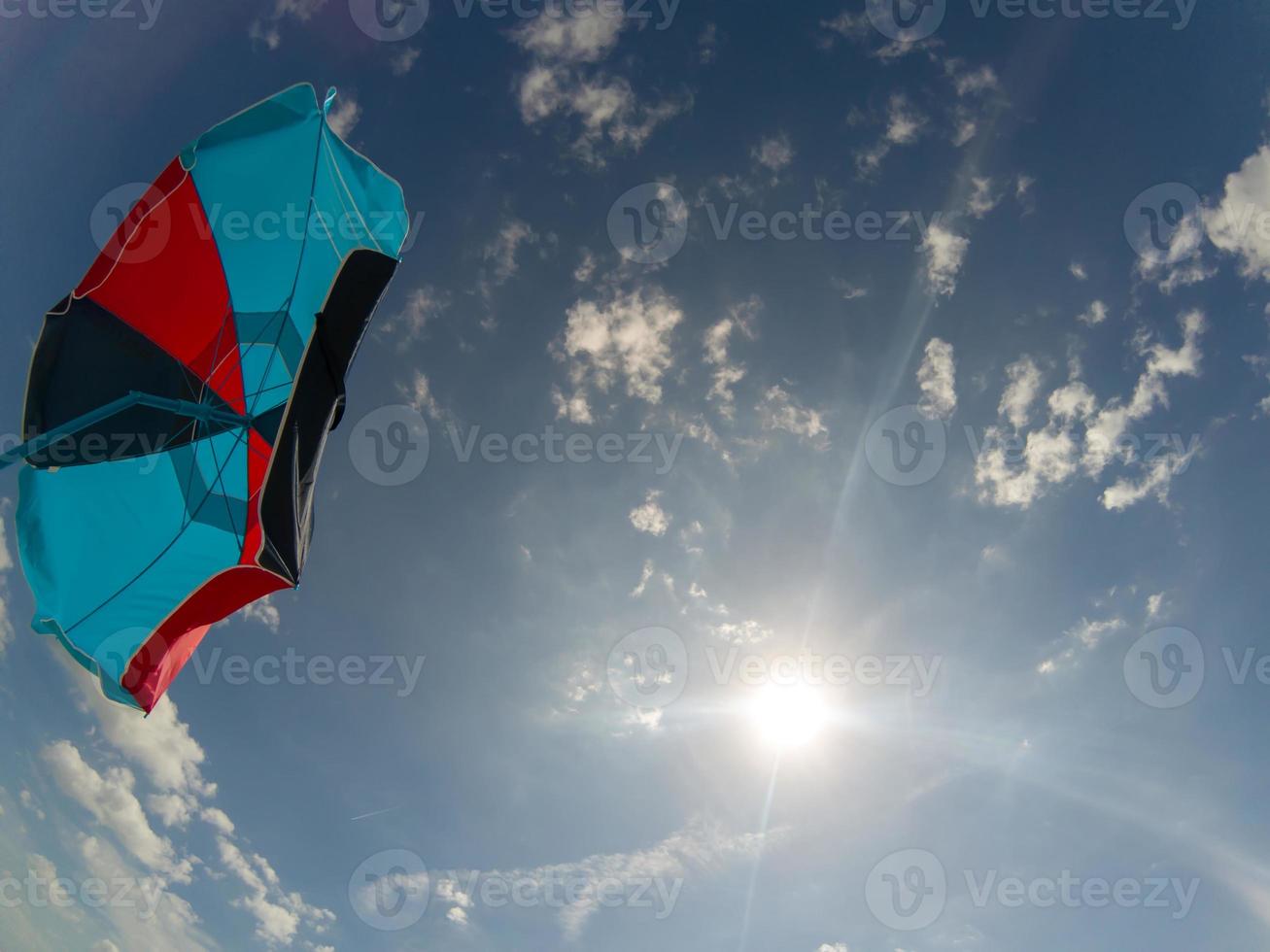 paraguas de colores en un día soleado en la playa foto