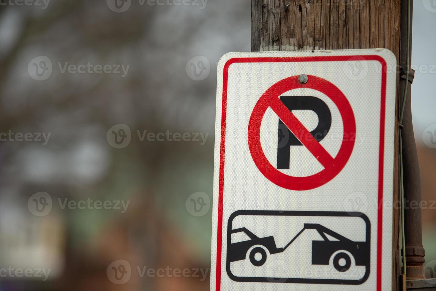 no parking tow sign on a street post photo