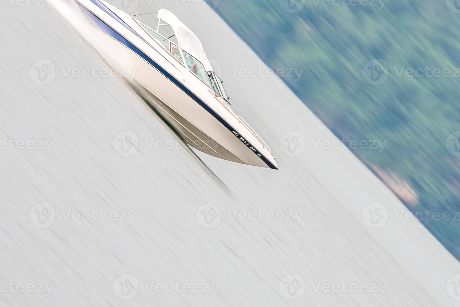 abstract blur of nature and fast moving boat on lake photo