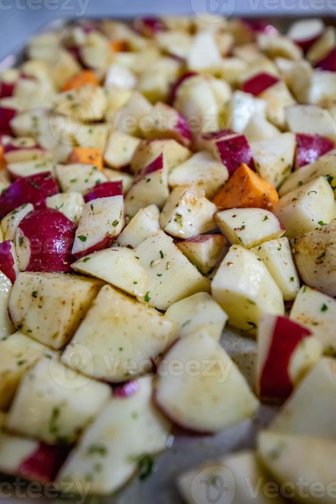 sliced and seasoned potatoes ready for roasting photo