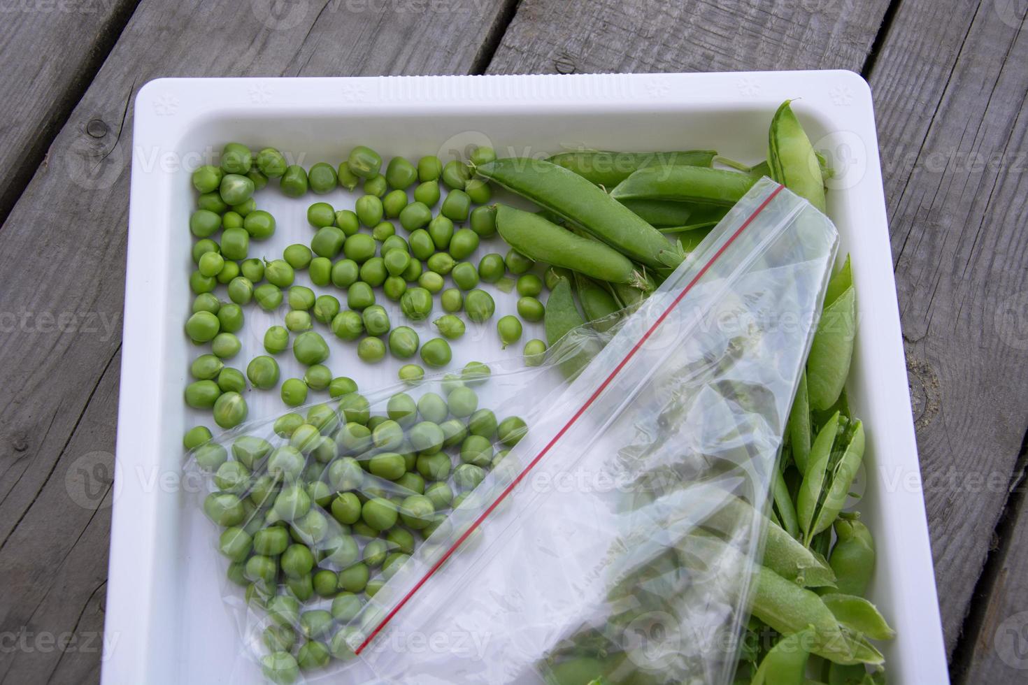 Los guisantes verdes están en una bolsa en una bandeja blanca. cosechando fresco foto