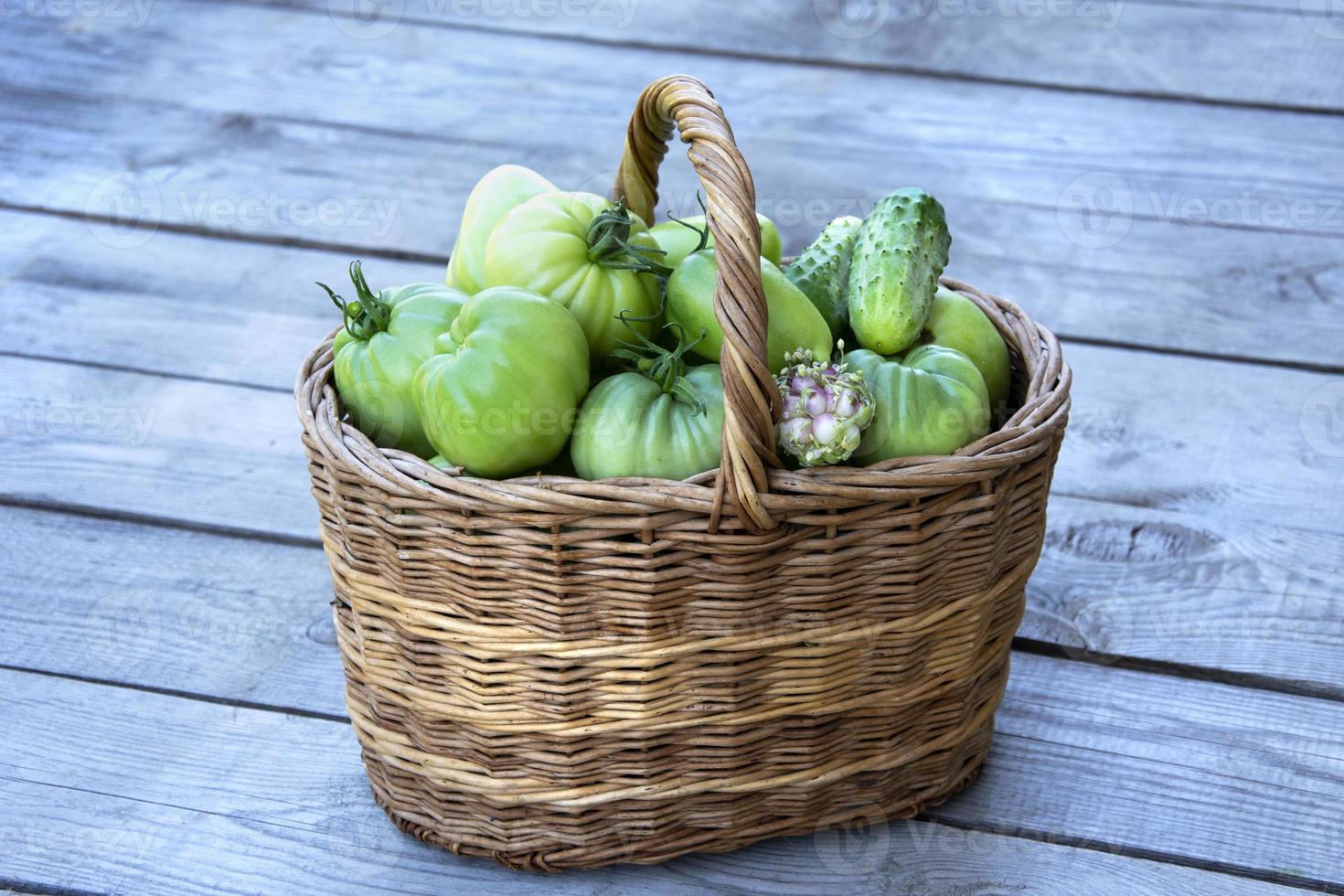 verduras en la canasta. una canasta de mimbre con tomates foto