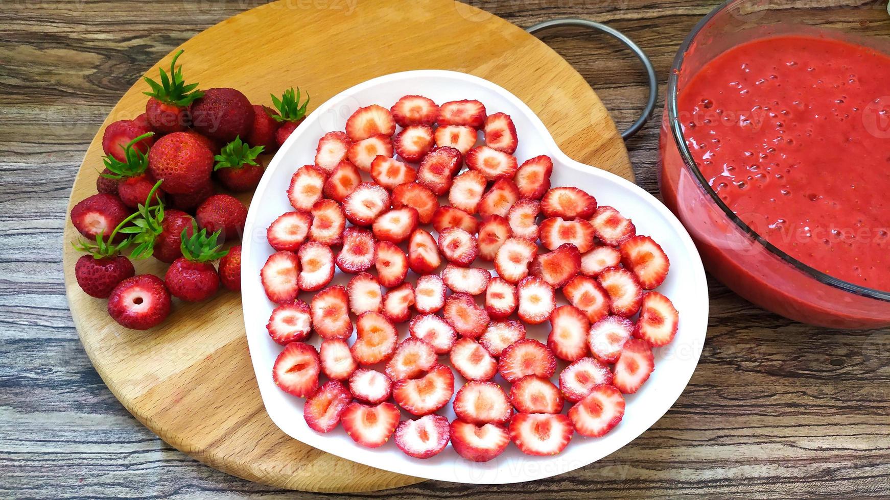 Whole red berries with leaves on a wooden background. Strawberry. photo