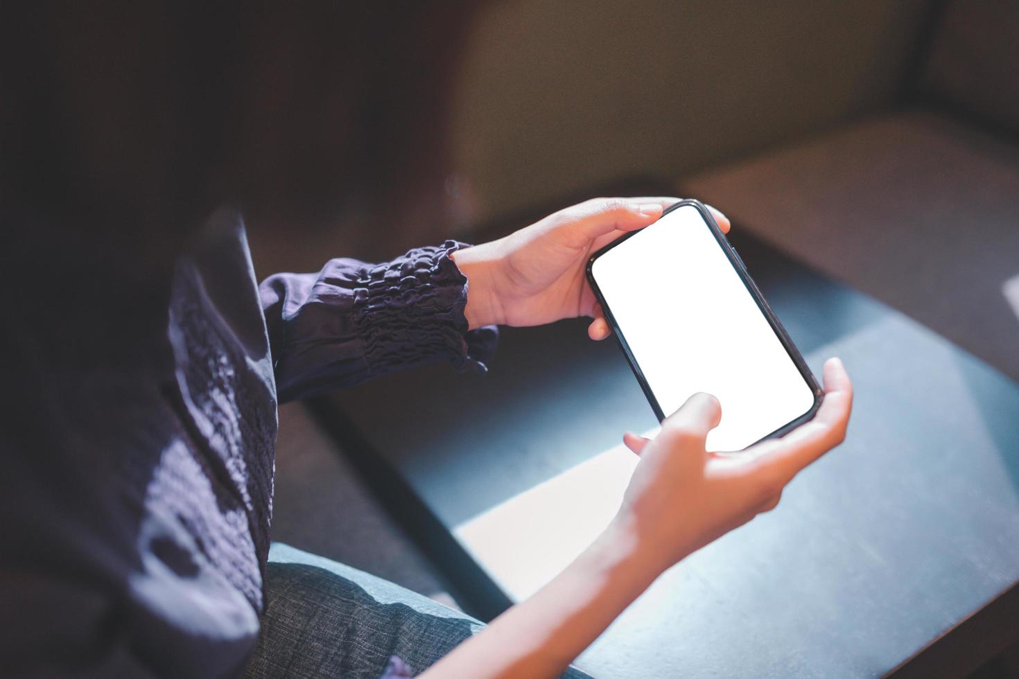 Young woman using smartphone with blank screen mockup photo