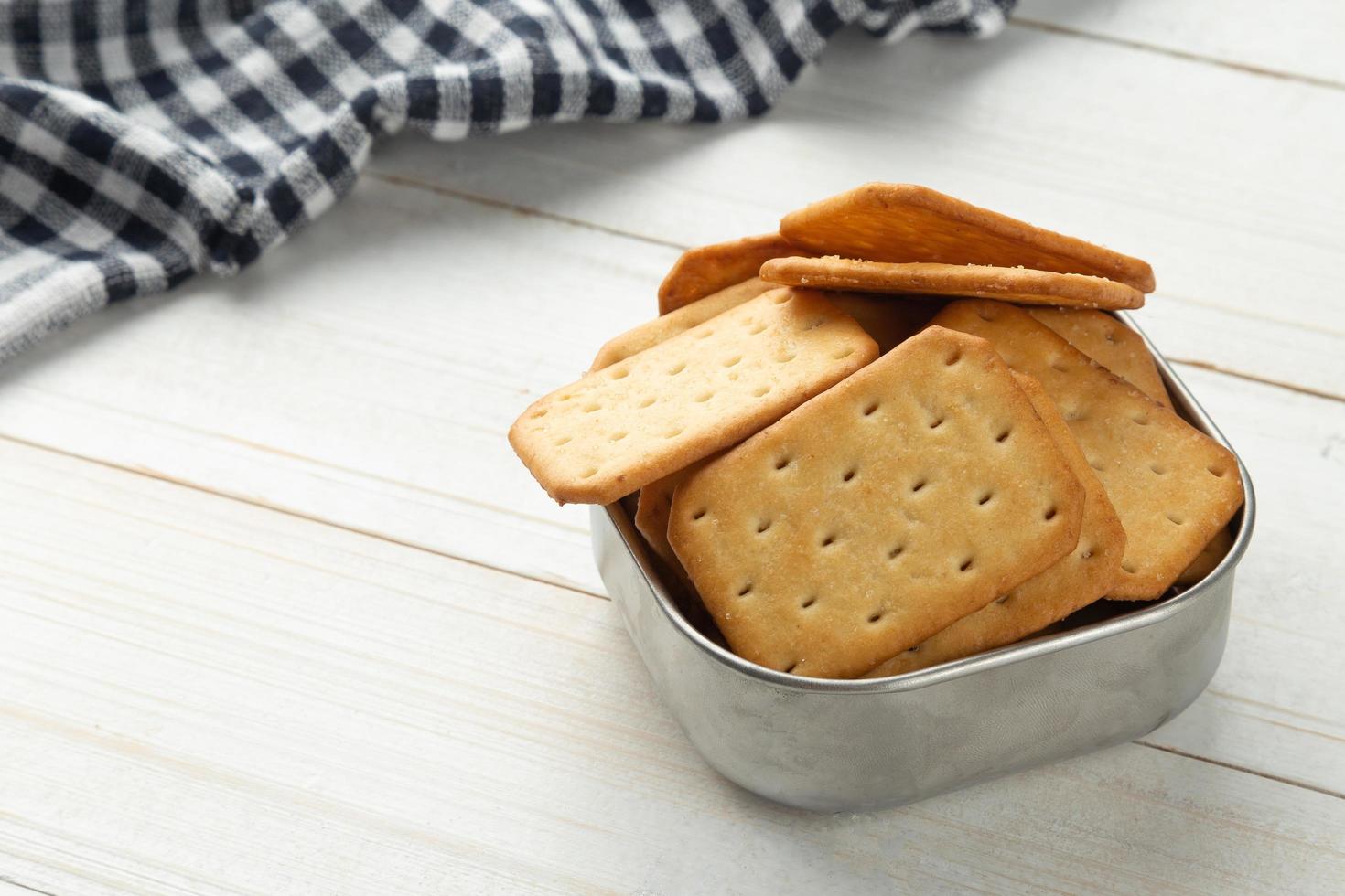 galletas saladas en un recipiente de acero inoxidable con mantel foto