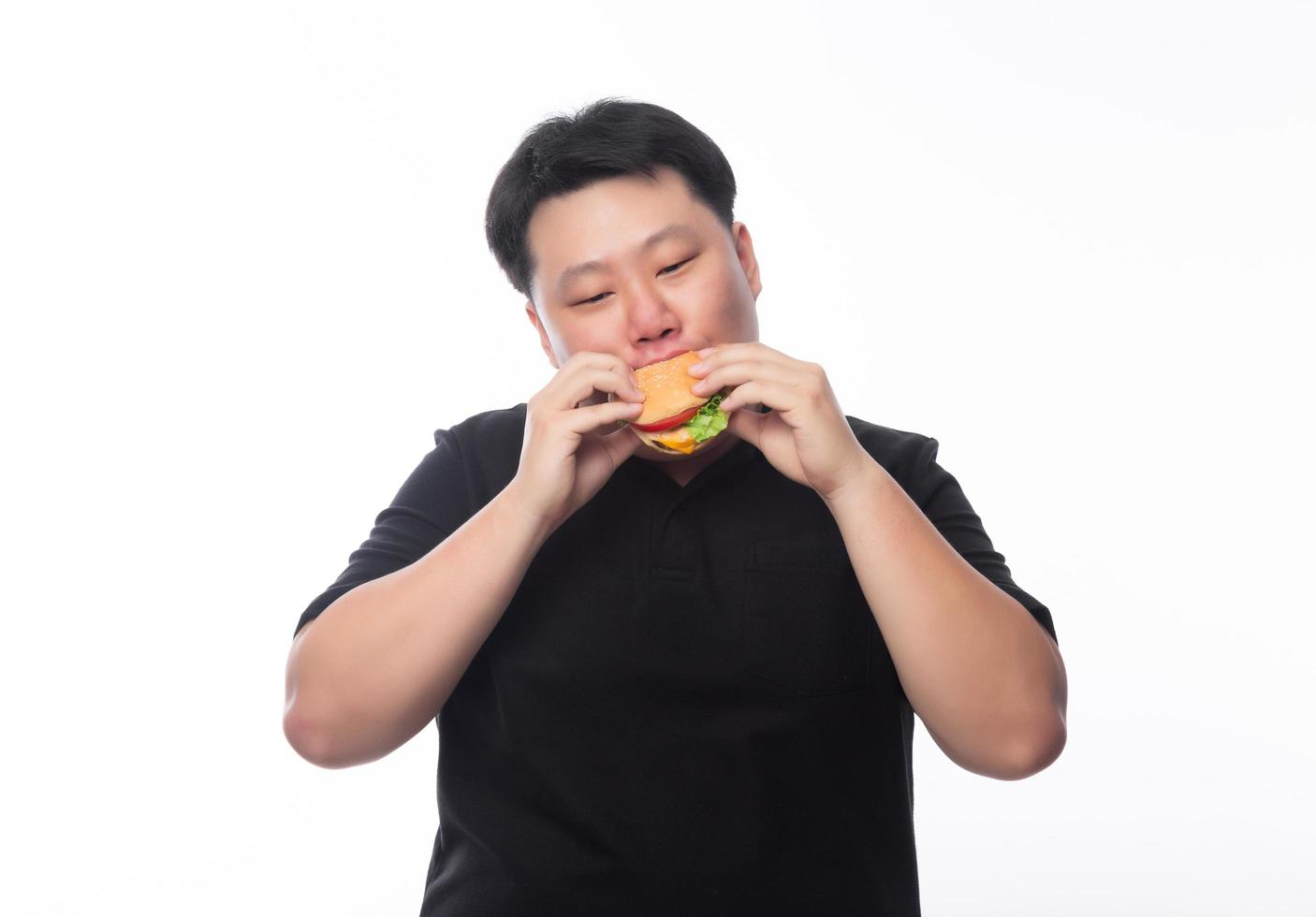 Fat Asian man eating hamburger photo