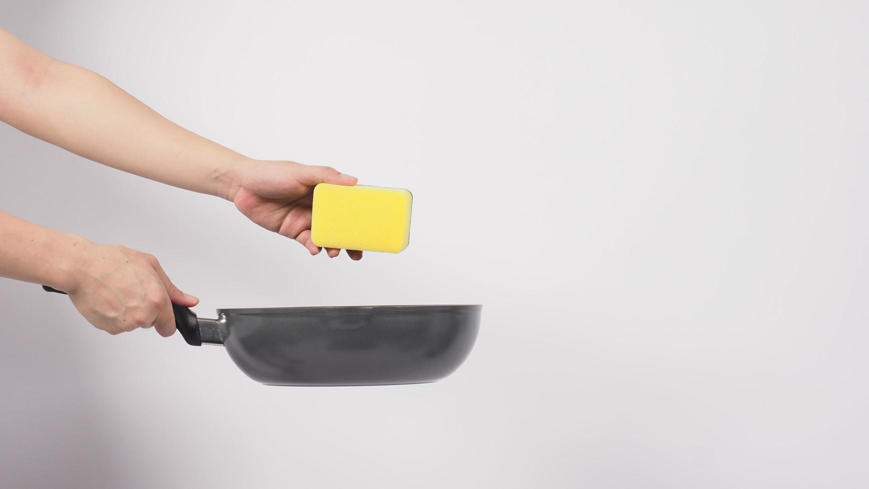 Man hand on white background cleaning the non stick pan photo