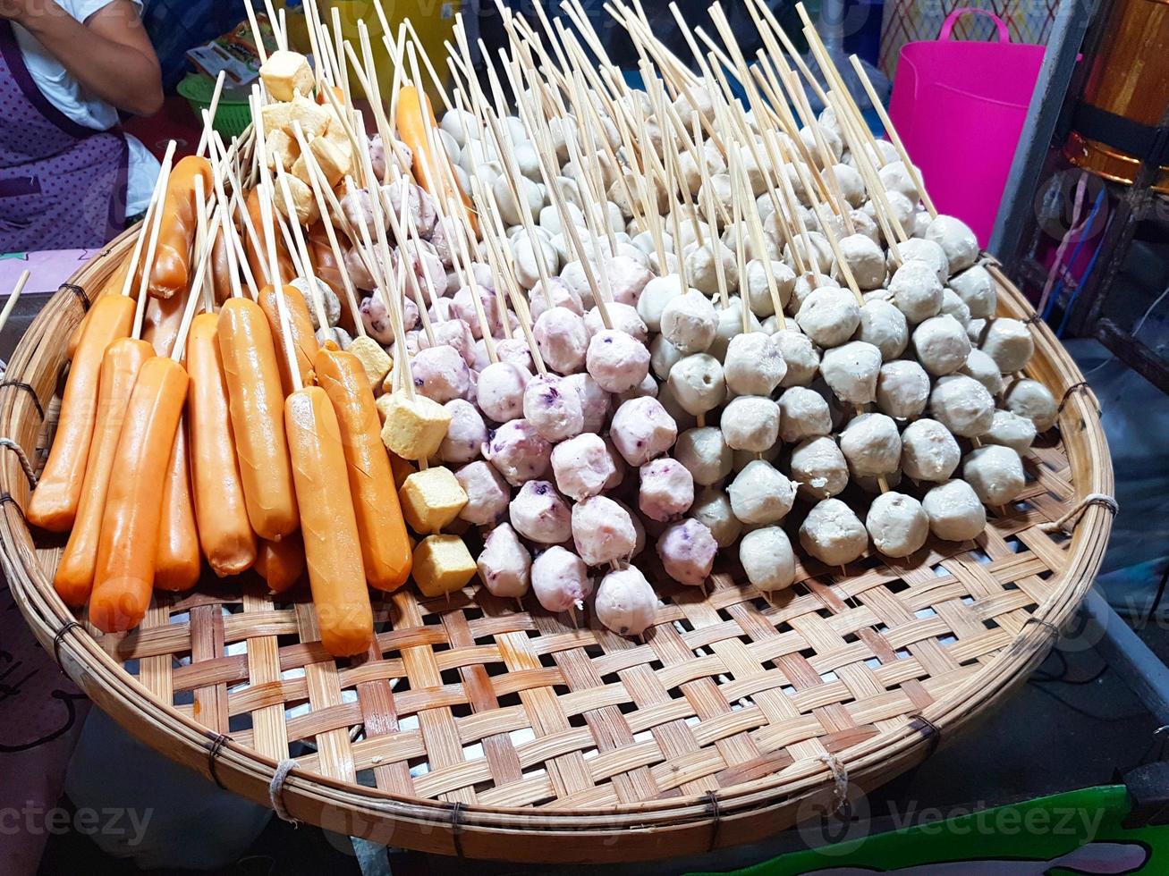 Meat balls and sausages steaming on wooden tray photo