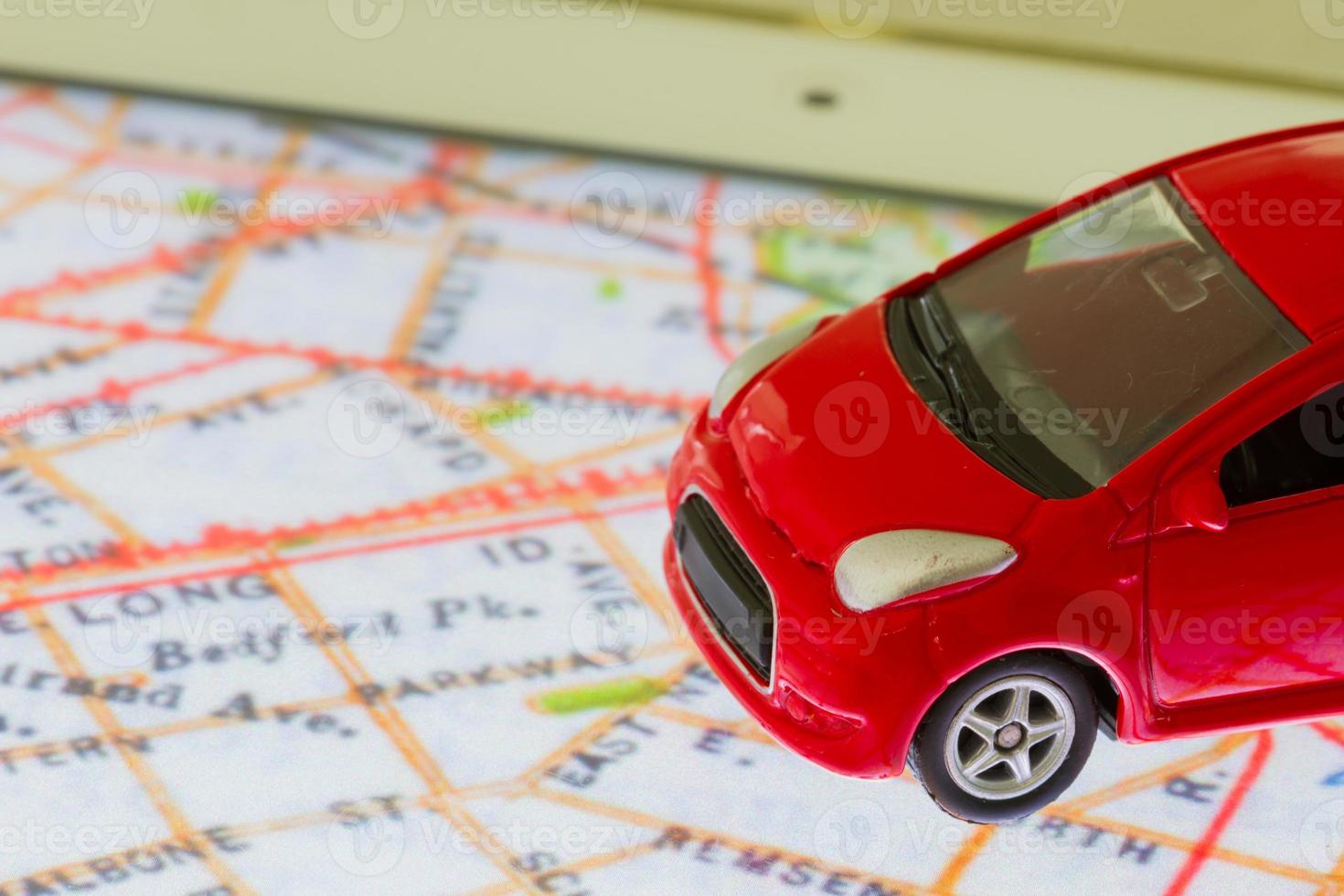 horizontal photo of closeup red car toy on the map in tablet screen