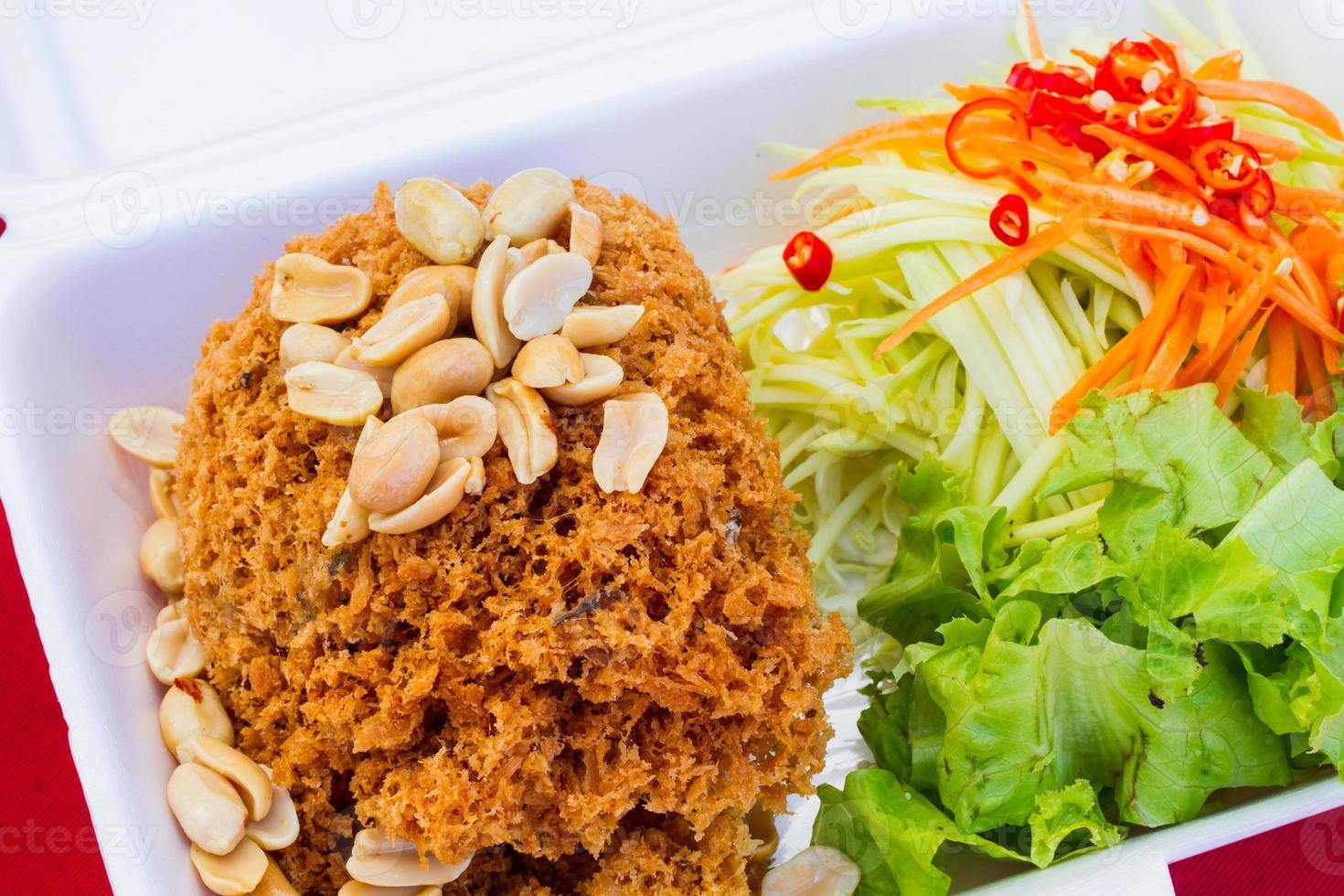 Ensalada crujiente de bagre en caja de espuma de poliestireno por vendedor de comida callejera de Tailandia foto