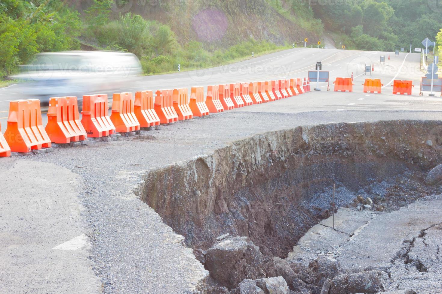 Carretera agrietada después del terremoto con barricada amarilla. foto