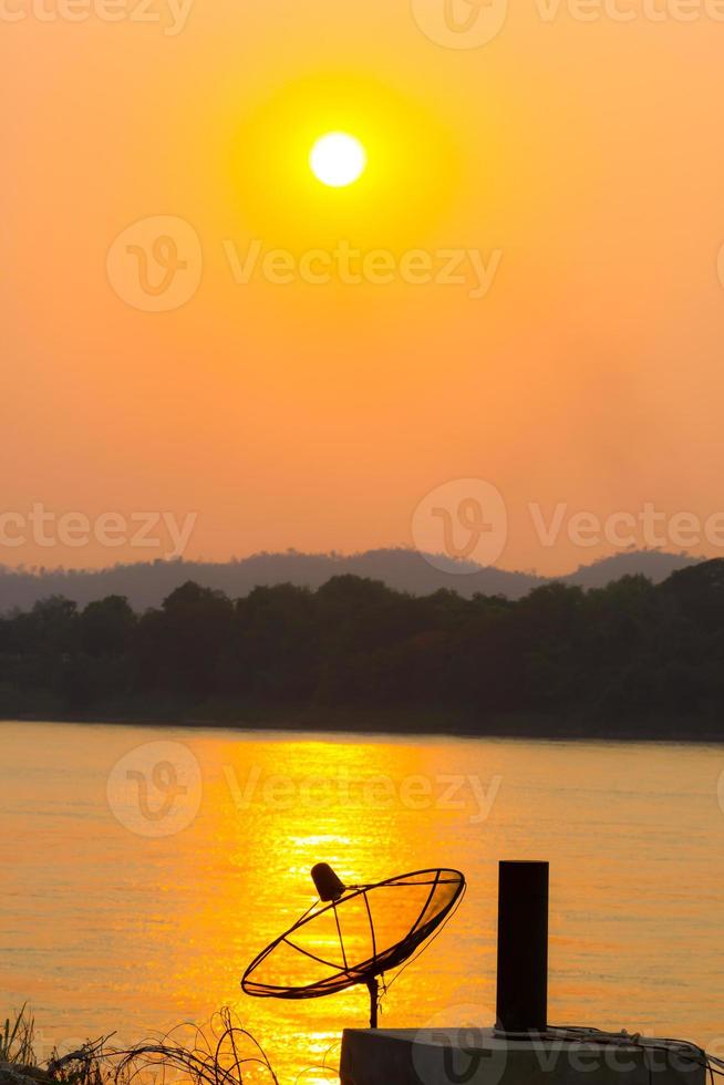 silhouette satellite dish on the reflection on the river photo