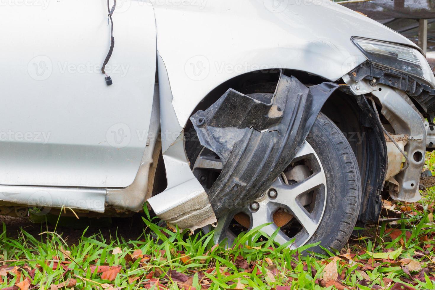 closeup damaged front wheel and bumper on green grass, safety concept photo